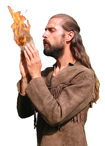 Photo of Chris Morasky Blowing a tinder bundle into flame.