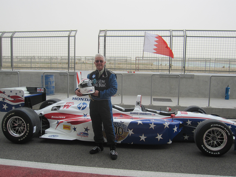 Photo of Nissen Davis suited up for a test drive in an IndyCar 2-seater at the Bahrain International Speedway before troops are taken for a ride