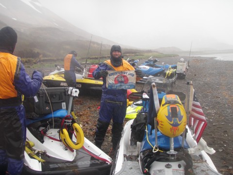Photo of Ralph Perez with other Racers holding the Adventurers' Club of Los Angeles Member Flag