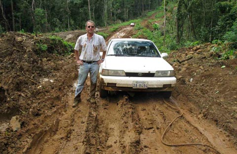 Photo of Daniel Robinson and his Camry, which had to be winched up a wet-season detour on the way up to Mondulkiri Province, Cambodia
